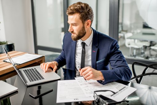 Makler mit Laptop und Dokumenten - Rendite